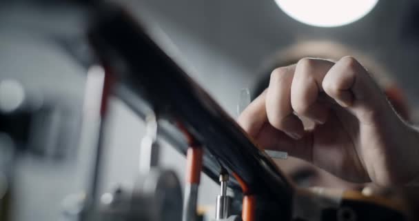 Luthier checks the fretboard radius of the electric guitar after sanding, repair of the musical instruments at the guitar workshop, 4k 60p 10 bit — Stock Video