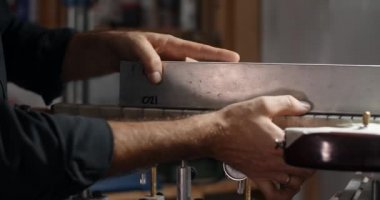 Luthier Sands, müzik aletleri tamir atölyesinde gitar çalıyor. 4k 60fps 10 bit.