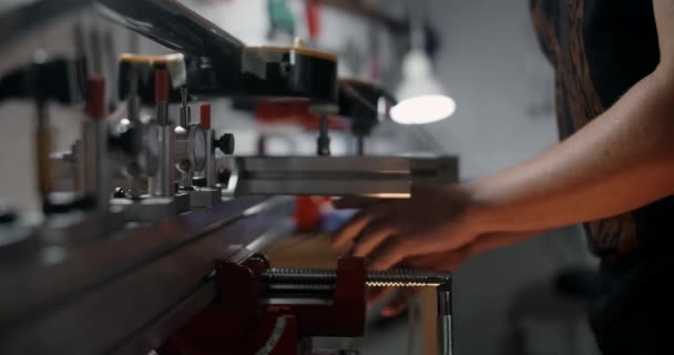 Luthier monta a guitarra elétrica no gabarito na loja de instrumentos musicais de reparação, 4k 60p 10 bit — Vídeo de Stock