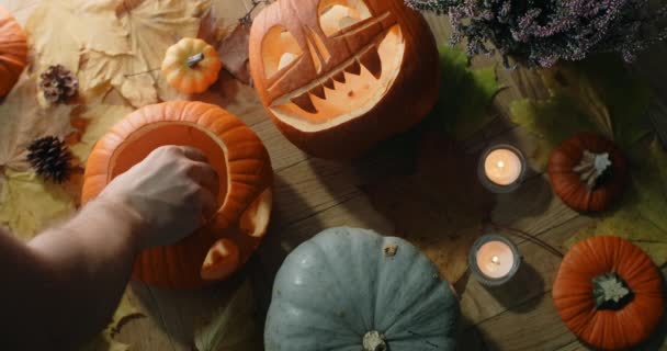 Tischplatte, auf der die Kerzen in den Halloween-Kürbiskopf gesteckt werden, Dekoration für Halloween, 4k 60p Prores HQ 10 bit — Stockvideo