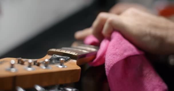 Gitar teknisyeni gitar fretboardunu yavaş çekimde, gitar servisi dükkanını 4k 60p 10 bit ile temizliyor. — Stok video