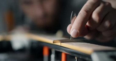 Luthier zımparaladıktan sonra elektro gitarın fretboard yarıçapını kontrol eder, gitar atölyesindeki müzik aletlerini tamir eder, 4k 60p 10 bit.