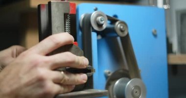 Marangoz atölyesinde küçük kereste parçalarını işlemek için kemer zımparası kullanır, 4k 60p 10 bit.