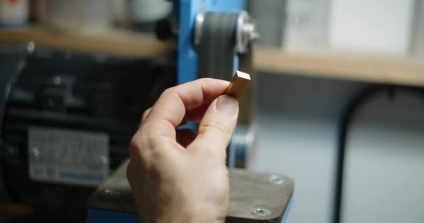 Stolarz używa szlifierki taśmowej w swoim warsztacie do obróbki drobnych elementów drewnianych, 4k 60p 10 bit — Wideo stockowe
