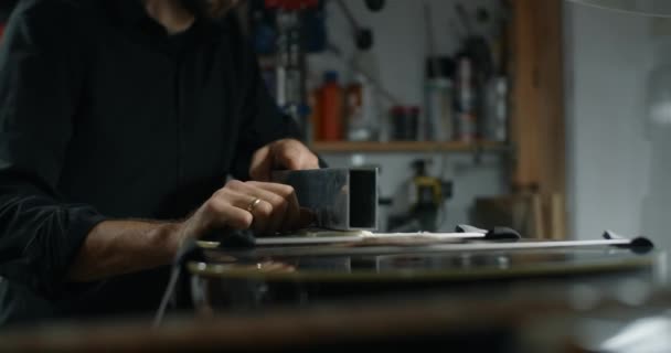 Лютье песок гитара беспокоит в мастерской по ремонту музыкальных инструментов, 4k 60fps 10 бит — стоковое видео