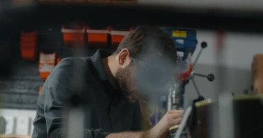 Gitar teknisyeni müzik aletleri atölyesinde gitarı tamir ediyor. 4k 60fps 10 bit.