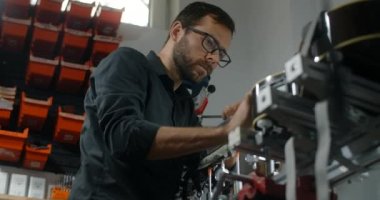 Luthier Sands, müzik aletleri tamir atölyesinde gitar çalıyor. 4k 60fps 10 bit.