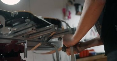 Gitar teknisyeni elektro gitarı müzik aletleri tamirhanesinde takıyor. 4k 60p 10 bit.