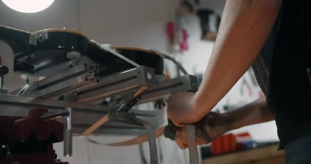 Гитарный техник монтирует электрогитару на джиге в мастерской по ремонту музыкальных инструментов, 4к 60р 10 бит — стоковое видео