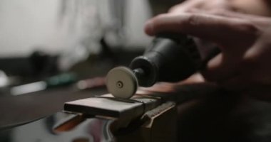 Luthier, müzik aletleri tamirhanesinde, 4k 60fps Prores karargahında gitar fretboardunda yeni perdeler parlatıyor.