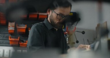 Luthier Sands, müzik aletleri tamir atölyesinde gitar çalıyor. 4k 60fps 10 bit.