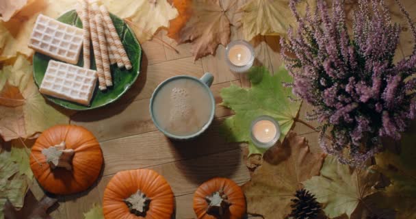 Tabletop video of decorated autumn composition in warm atmosphere with waffles, leaves and tea with milk, 4k 60p Prores HQ — Stock Video