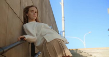 Uzun bacaklı ve mini giyinmiş manken, genel merdivenlerde yavaş çekimde poz veriyor, 4k 120 fps Prores karargahı.