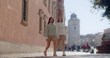 İki dansçı kadın eski kasabanın caddesinde jimnastik esneme egzersizleri yapıyor, koreografi performansı sokakta, 4k 60p Prores HQ