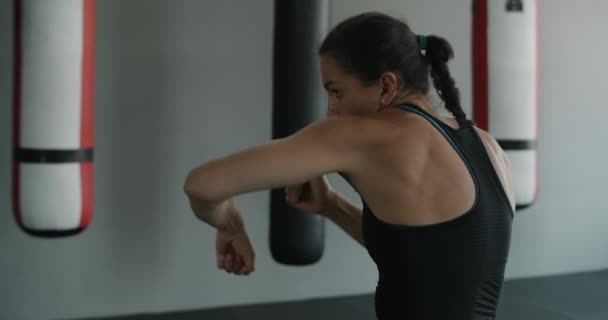 Μικτή μαχήτρια πολεμικών τεχνών κάνει πυγμαχία σκιά στο fight club, θηλυκό kickboxer παλεύει με σκιά στο γυμναστήριο, 4k 120fps Prores HQ — Αρχείο Βίντεο