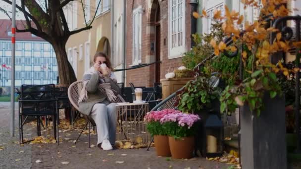 Τουριστική γυναίκα σε γυαλιά ηλίου πίνει ζεστό καφέ στο δρόμο καφέ της παλιάς πόλης το φθινόπωρο, 4k 60p αργή κίνηση — Αρχείο Βίντεο