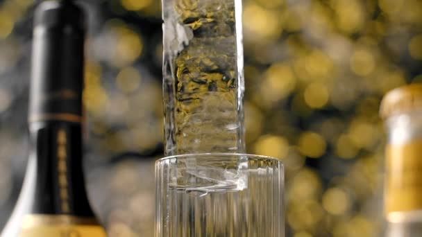 Lange ijsblokje wordt in slow motion op het highball glas gedropt met de fles alcohol op de achtergrond, Full HD Prores HQ 240 fps — Stockvideo