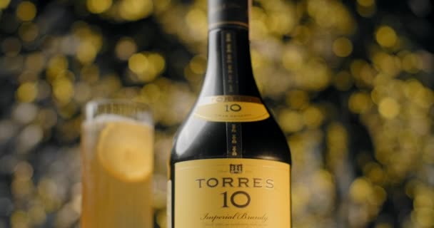 GARANTIA, POLÓNIA - SETEMBRO 12, 2021: zoom out footage of isolated bottle of Torres brandy drink with cocktail in the background, 4k 60p Prores HQ — Vídeo de Stock