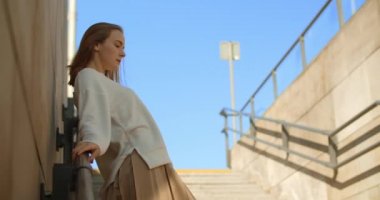 Uzun bacaklı ve mini giyinmiş manken, genel merdivenlerde yavaş çekimde poz veriyor, 4k 120 fps Prores karargahı.