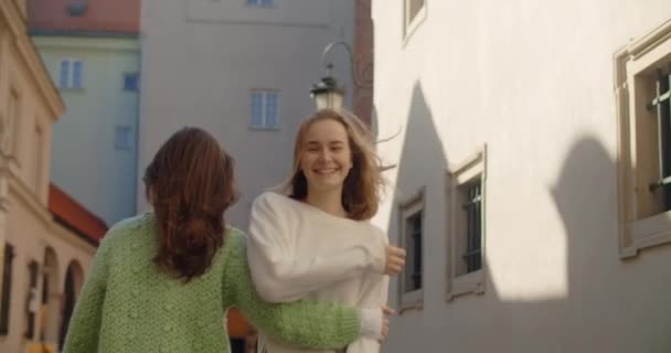 Молодые женщины ходят вместе в замедленной съемке на улице. Модное стильное видео двух девушек в повседневной одежде, гуляющих по старому городу, 4k 60p Prores HQ — стоковое видео
