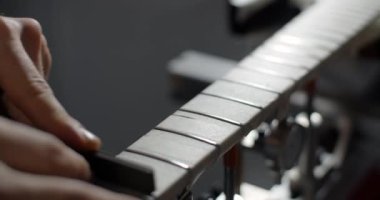 Luthier müzik aletleri tamir atölyesinde gitar perdeleri öğütüyor, 4k 60fps 10 bit.