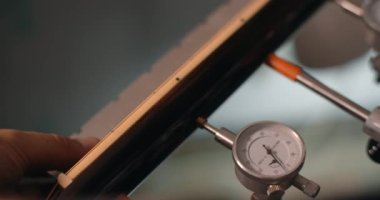 Luthier, mağazadaki müzik enstrümanlarını tamir ederken gitar yakasının fretboard açısını ölçüyor. 4k 60p 10 bit.