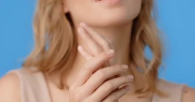 Sarışın güzel kadın ellerine cilt kremi sürüyor. Kadınların kozmetik kullanımı. Mavi ekranda güzellik hizmetleri prosedürleri, 4k Prores Merkezi