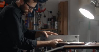 Luthier Sands, müzik aletleri tamir atölyesinde gitar çalıyor. 4k 60fps 10 bit.