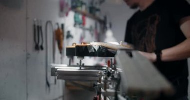 Gitar teknisyeni elektro gitarı müzik aletleri tamirhanesinde takıyor. 4k 60p 10 bit.