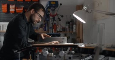 Luthier Sands, müzik aletleri tamir atölyesinde gitar çalıyor. 4k 60fps 10 bit.