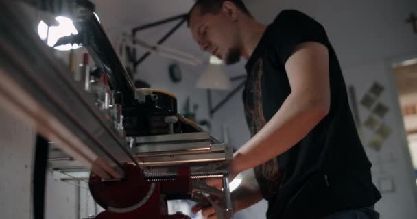 Guitar tech monte la guitare électrique sur le gabarit à l'atelier de réparation d'instruments de musique, 4k 60p 10 bits — Video