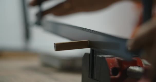 Craftsman saws pedaço de latão trancado na braçadeira vise. Peças feitas à mão para instrumentos musicais, 4k 60p Prores — Vídeo de Stock