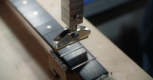 Process av press montera frets i gitarr fretboard på luthiers verkstad, gitarr reparation, 4k 60p Prores HQ — Stockvideo