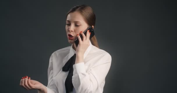 Takım elbiseli genç yönetici kadın cep telefonuyla konuşuyor, itirazlarla uğraşıyor, telefonla satıyor, 4k 120 fps Prores karargahı. — Stok video