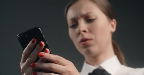 Mujer europea irritada e insatisfecha pasa la pantalla del teléfono inteligente en un apuro, trabajador de oficina enojado utiliza el teléfono, 4k Prores HQ 10 bit — Vídeos de Stock
