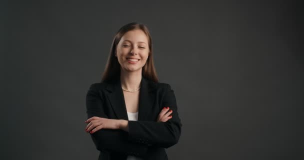 Mulher de negócios europeia de terno preto relógios para a câmera e sorrisos, 4k Prores HQ — Vídeo de Stock