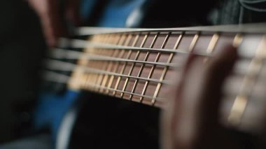 Bassplayer parmaklarıyla modern 5 telli bas gitar çalar. Yavaş çekimde, 1080p 240 fps.