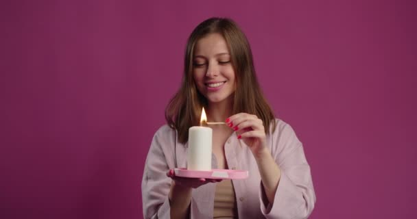 Woman in pajamas lights the big candle with match in slow motion, 4k Prores HQ — Wideo stockowe