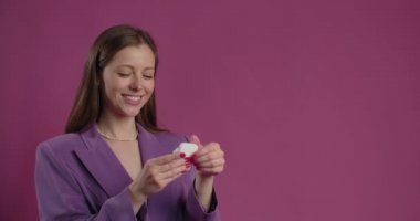 Happy woman opens the box with bluetooth headphones and inserts them to her ears, unpacking and using the earphones, listening the music on streaming platforms, 4k Prores HQ 60fps