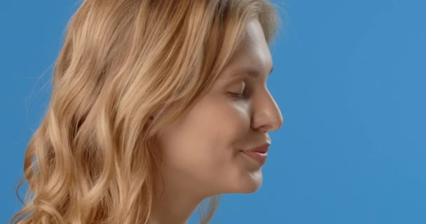 Blonde woman sprays micellar water to her face. Womens cosmetics usage. Beauty care procedures on blue screen, 4k Prores HQ — Stock videók