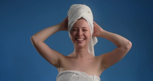 Portrait of pretty woman with towel on her head applying face care by fingers in slow motion. Womens cosmetics usage. Beauty care procedures on blue screen, 4k Prores HQ — Vídeos de Stock