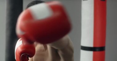 Boxer man in red boxing gloves does shadow boxing and trains at boxing club, fighter man is fighting with shadow on boxing ring, kickboxer training strikes in gym, 4k 60p Prores HQ
