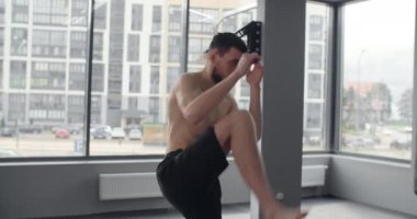 Mixed martial art fighter does shadow boxing and trains at boxing club, fighter man is fighting with shadow, kickboxer training strikes in gym, 4k 60p Prores HQ
