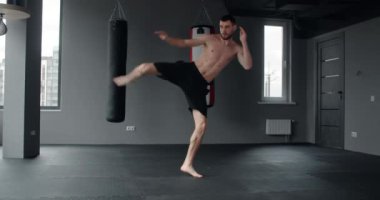 Mixed martial art fighter does shadow boxing and trains at fighter club, fighter man is fighting with shadow, kickboxer training strikes in gym, 4k 60p Prores HQ