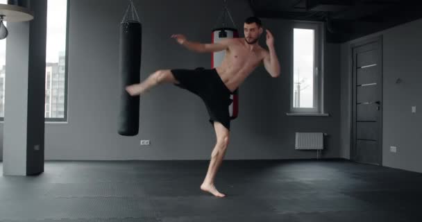 Mixed martial art fighter does shadow boxing and trains at fighter club, fighter man is fighting with shadow, kickboxer training strikes in gym, 4k 60p Prores HQ — Stok video