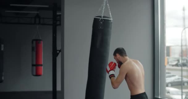 Kickboxer golpea bolsa de boxeador por sus brazos y piernas en cámara lenta en el entrenamiento, entrenamiento en el club de lucha, artes marciales mixtas, 4k 60p Prores — Vídeos de Stock