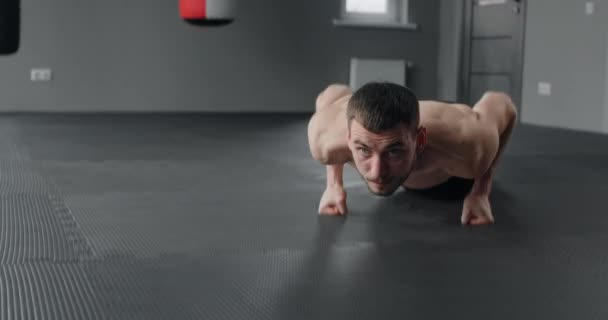 Athlete performs fast push-ups on his fists at the gym, camera follows the movement, workout training, 4k 60p Prores HQ — ストック動画