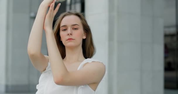 Young dancer in white dress dances on the stairs of the theatre in slow motion, balerina does dance steps and pa outdoors, 4k 120 fps Prores HQ — Vídeos de Stock