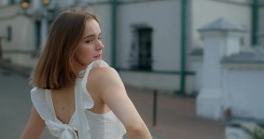 Portrait of the woman dancer in white dress that dances gracefully in slow motion outdoors, balerina does dance pa and movements outdoors, 4k 120 fps Prores HQ