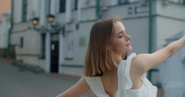 Portrait of the woman dancer in white dress that dances gracefully in slow motion outdoors, balerina does dance pa and movements outdoors, 4k 120 fps Prores HQ — Stock video